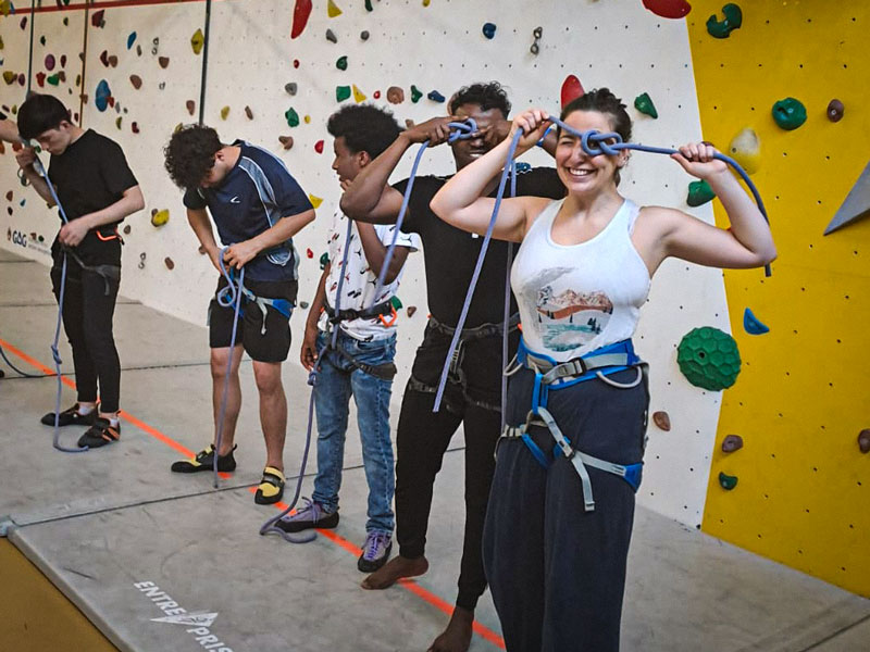 woman in white t-shirt and black leggings sitting on blue and yellow floor